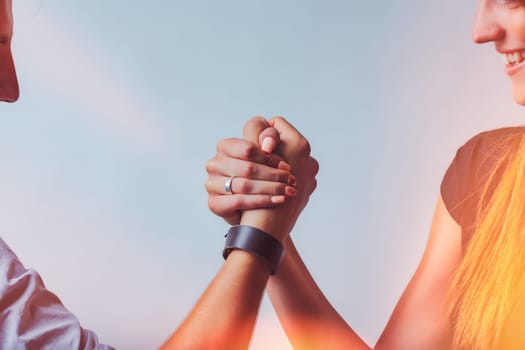 couples clasped hands and focused faces evoke a symbolic moment of unity and strength. They smile, balancing playful competition with mutual respect and shared determination