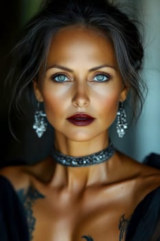 Close-up portrait of a middle-aged woman with black hair, blue eyes and dark red lipstick earrings and necklace. She has tattoos on her arms. AI generative.