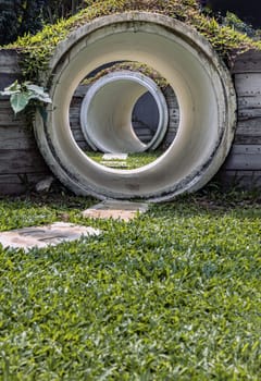 Bangkok, Thailand - Feb 19, 2025 - Outdoor playground with The kid's playing tunnel with Grass mound on top in the park for children. Park concrete tunnel made for Children's play as a rabbit, ducking through its numerous burrows, use it as your Copy space, Design, Wallpaper and Poster, Selective focus.