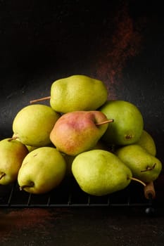 A pile of green pears on a brown background