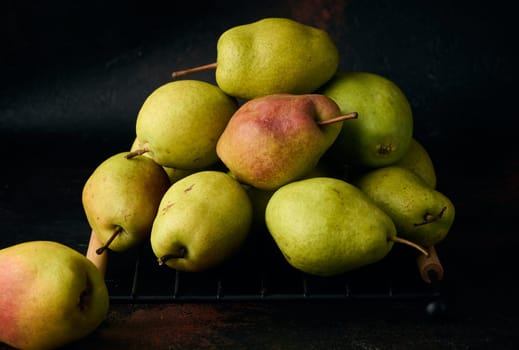 A pile of green pears on a brown background