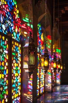 Islamic lanterns with stained glass panels, casting colorful patterns when illuminated.