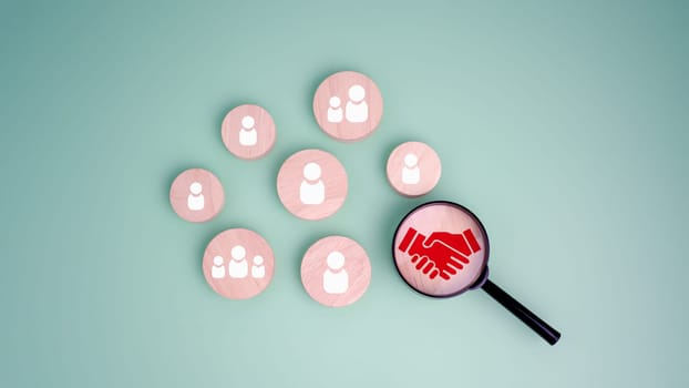 Hand shaking icon printed on wooden plate and focused with a magnifying glass and human in circle icon for business deal concept. Teamwork process of partner, Best relationship, For business contract