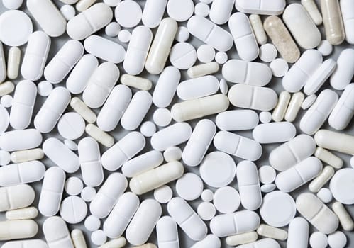 Mix of medical capsules and pills on grey top view. Preventive medicine and healthcare, taking dietary supplements and vitamins. Assorted pharmaceutical medicine capsules