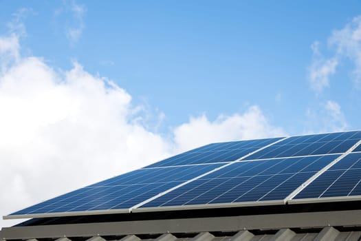 Aerial view of solar panel cells against cloudy blue sky. Alternative energy concept, sustainable resources. House with solar panels stand-alone photovoltaic plant system. Professional installation