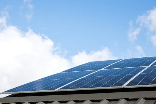 Aerial view of solar panel cells against cloudy blue sky. Alternative energy concept, sustainable resources. House with solar panels stand-alone photovoltaic plant system. Professional installation