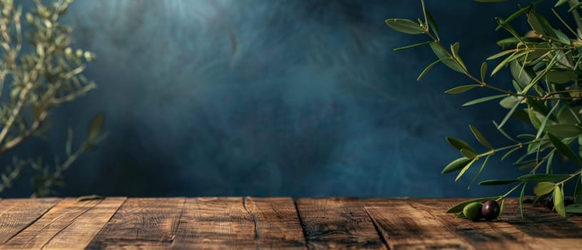An olive branch with dark berries sits on a wooden ledge, against a dramatic blue background with a moody ambiance