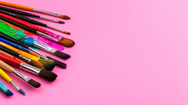 Brushes lie on a pale pink background of soft pastel shades. High quality photo