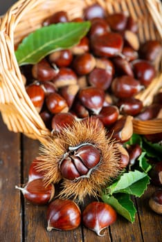 Chestnut with leaves on a wooden background