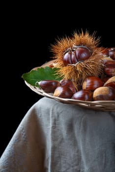 Chestnut with leaves on a wooden background