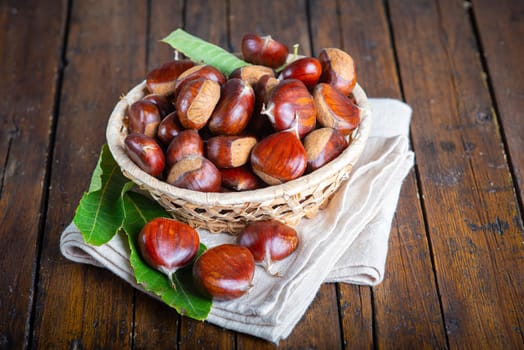 Chestnut with leaves on a wooden background