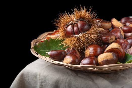 Chestnut with leaves on a wooden background