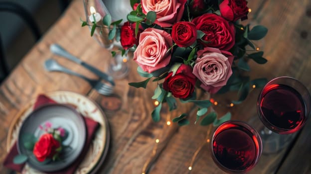 A romantic dinner setup with wine glasses and a bouquet of roses on a rustic wooden table, captured from a high angle