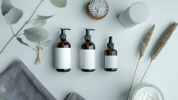 Three bottles of perfume are displayed on a table with a towel and a brush. The bottles are brown and white, and the towel is gray. The brush is placed next to the bottles