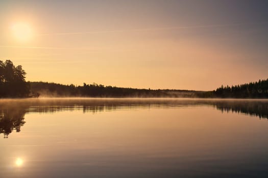 Lake in Sweden, mirror-smooth water with romantic light and trees on the shore. Scandinavian nature in the north