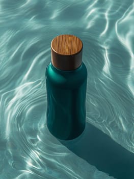 A teal water bottle with a wooden cap rests gently on the surface of sunlight-dappled water, creating a calming visual effect.