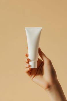 A hand holds a minimalist white tube against a soft beige background, emphasizing simplicity and elegance in design.