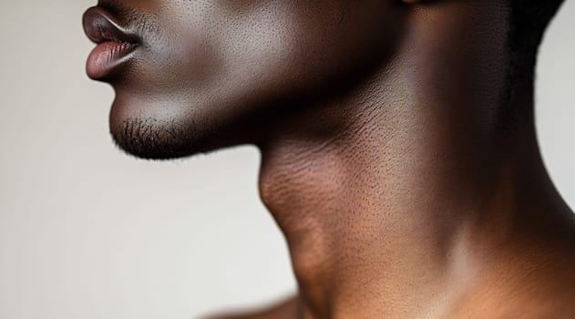 A close-up view of a man's neck showcases smooth skin and defined contours, illuminated by soft, natural light.