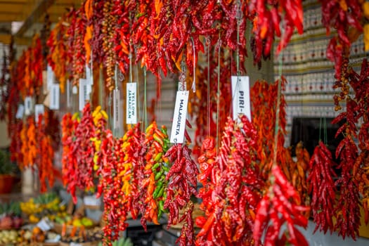 Funchal, Madeira, Portugal, November 7th 2024: View on peppers and fruits in a market stall of Mercado dos Lavradores, Farmers market, in Funchal, Madeira