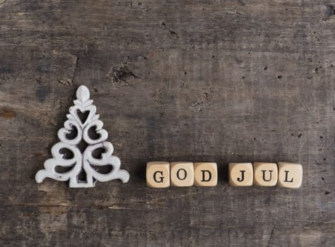 Christmas tree shape with wooden blocks and the words God Jul, Scandinavian Merry Christmas on a wooden background