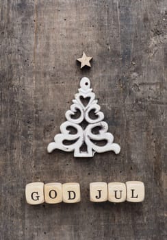 Christmas tree shape with wooden blocks and the words God Jul, Scandinavian Merry Christmas on a wooden background