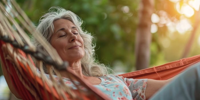 A woman is relaxing in a hammock, enjoying the sunshine and the outdoors. She is smiling and she is in a peaceful state of mind