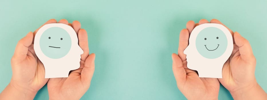 Holding a head with a sad and a happy face, mental health concept, positive and negative mind, depression, support and emotion, divided personality