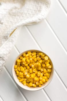 Canned sweet corn in bowl on a white table.