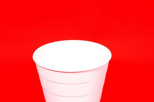 White buckets isolated on red background in a studio
