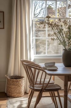 A warm, inviting dining space features a wooden table, a simple chair, and a vase filled with flowers by the window.