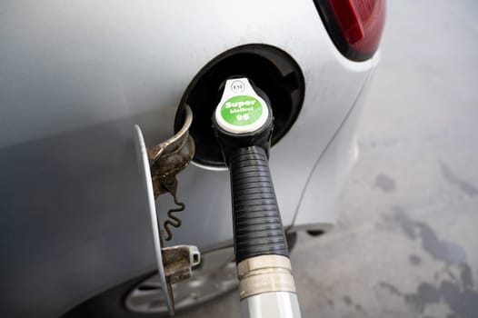 Gasoline dispenser to add gas to car, gas station with petrol and diesel fuel pump nozzles, increase of costs