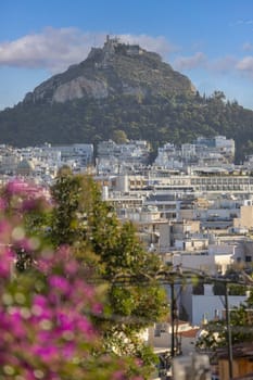 Athens, Greece - October 19, 2022: Aerial view from Anafiotika of city and limestone Mount Lycabettus, highest point in Central Athens