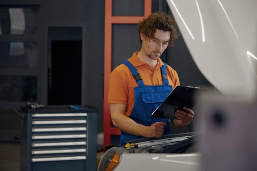 Mechanic looking under car hood checking engine operation work. Auto diagnostic and repair service concept