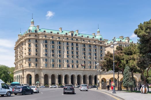 Baku, Azerbaijan - May 10, 2024: Beaux-Arts style Four Seasons Hotel stands on Neftchiler Avenue street. The building features a symmetrical facade with multiple stories, arched windows, and domes