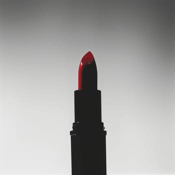 Striking silhouette of a lipstick bullet poised for application.