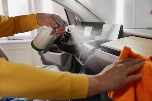 Professional service master working at car wash service providing professional safety leather dirt cleansing and treatment procedure