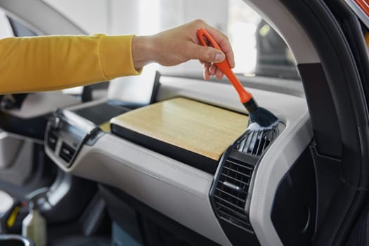 Cropped shot of male master cleaning side sills using professional tools and automotive shampoo
