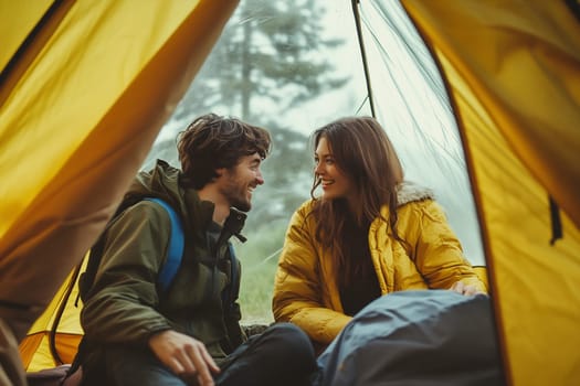 A couple enjoys a warm, happy moment together inside a tent surrounded by nature, soaking up the tranquility of the great outdoors.