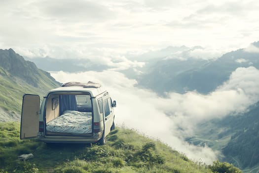 A camper van is parked on a mountain overlook with a bed inside, surrounded by cloudy skies and distant peaks.
