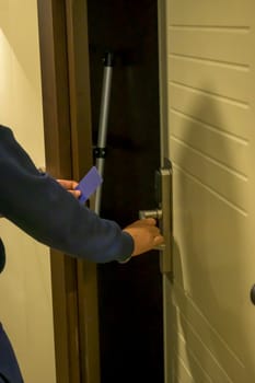 Latin young men opens a door with a keycard in a hallway, key electronic lock, hotel room, holidays in mallorca, spain.