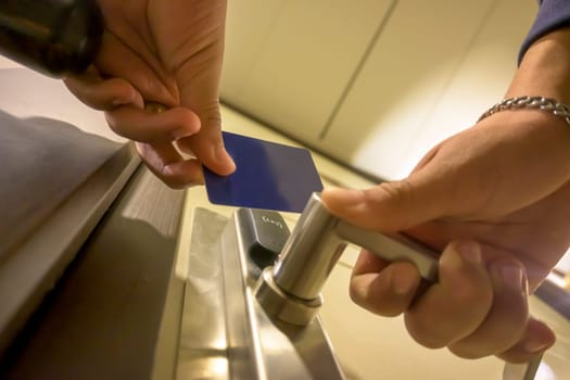 Close-up of a hand using a blue card key in a hotel door lock, key electronic lock, hotel room, holidays in mallorca, spain