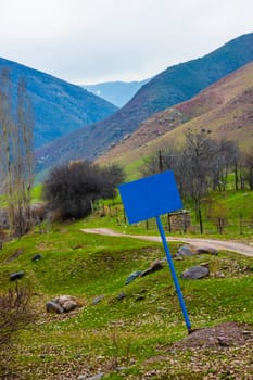 a crooked blank blue sign on a steel pole at the entrance to mountain gorge