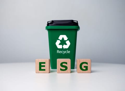 Green ESG icon symbol on wooden block with recycling bin and investment in sustainable green business. ESG concept about environment, social and governance, Sustainable and environmentally concept.