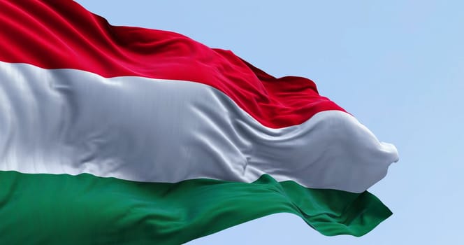 Close-up of Hungary national flag waving in the wind on a clear day. Horizontal striped flag of red, white and green. 3d illustration render. Fluttering fabric