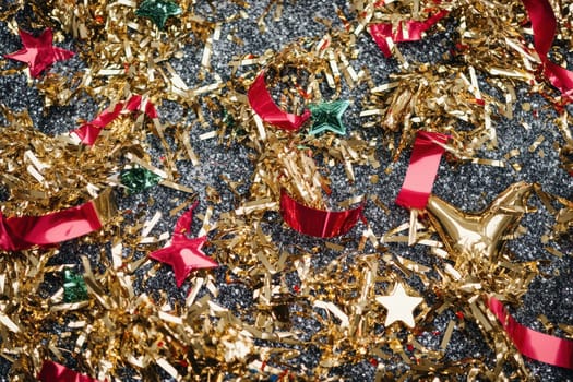 Bright gold and red decorations are scattered across a dark surface creating a festive and cheerful atmosphere for celebrations.