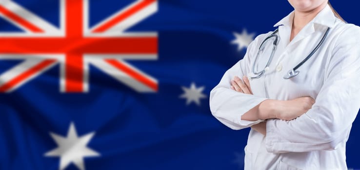 Doctor with crossed arms on Australian flag. Australian Health and Care concept. Female doctor on Australia flag