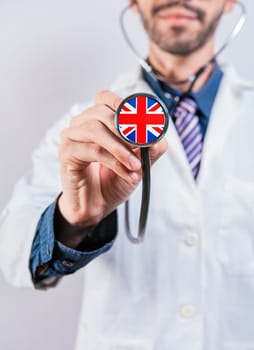 UK health and medical insurance concept. Healthcare System UK, doctor holding stethoscope.