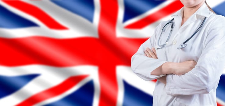 Doctor with crossed arms on UK flag. UK Health and Care concept. Female doctor on UK flag