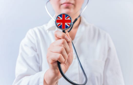 Doctor showing stethoscope with UK flag. UK National Healthcare concept.