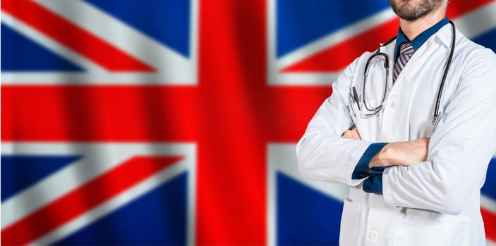 Doctor with crossed arms on British flag. UK Health and Care concept. Professional doctor on British flag